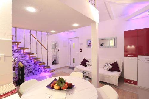 a living room with a table with a bowl of fruit on it at Apartments Ella in Split