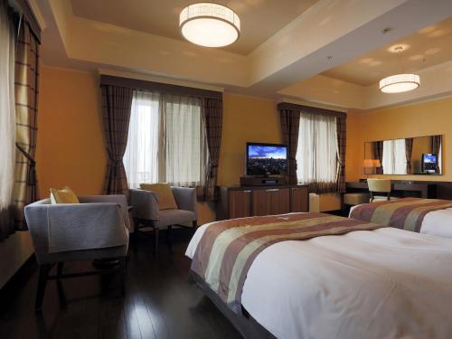 a hotel room with two beds and a flat screen tv at Hotel Monterey La Soeur Osaka in Osaka