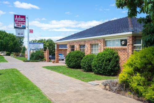 a brick house with a sign in front of it at Golden Chain Aalana Motor Inn in Cowra