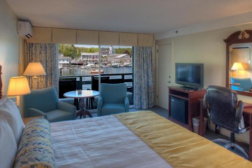 Habitación de hotel con cama, escritorio y TV. en Browns Wharf Inn, en Boothbay Harbor