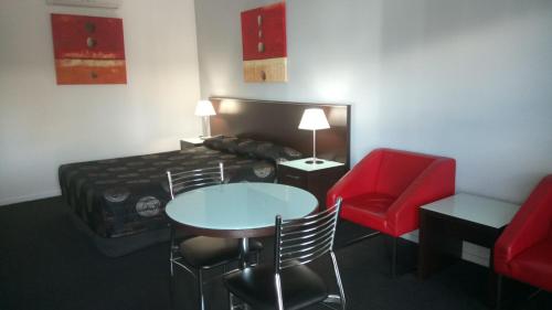 a room with a bed and a table and chairs at Gympie Muster Inn in Gympie