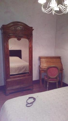 a bedroom with a mirror and a bed and a chair at Villa SAINT-PRIVAT in Pouzilhac