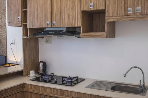 a kitchen with wooden cabinets and a stove top oven at Surf4You Residence in Mui Ne