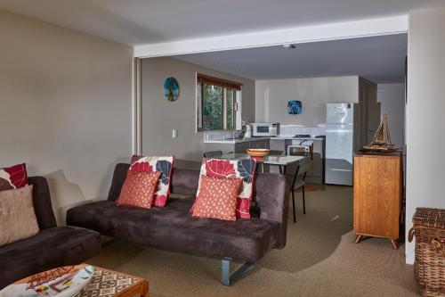 a living room with a couch and a kitchen at Akaroa on the Beach in Akaroa