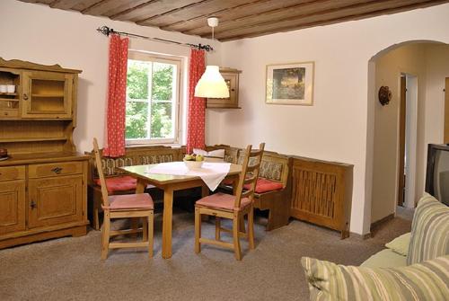 un comedor con mesa y sillas en una habitación en Appartementhaus Huber en Abersee 