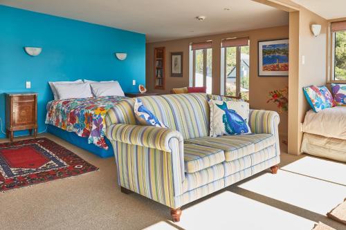 uma sala de estar com um sofá e uma cama em Akaroa on the Beach em Akaroa
