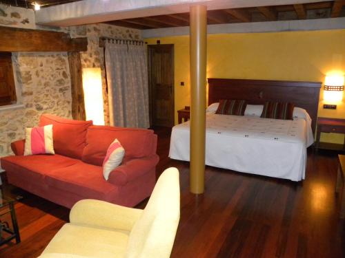 a bedroom with a bed and a couch in a room at Posada Los Templarios in Ucero
