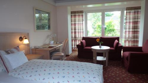 a hotel room with a bed and a living room at Hotel Historischer Krug in Oeversee