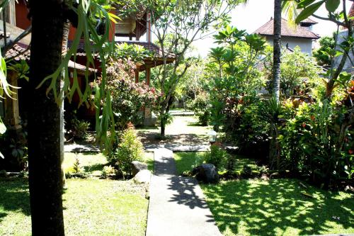 a garden with a pond in the middle of a house at dewi ayu accomodation in Ubud