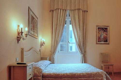 sypialnia z łóżkiem i oknem w obiekcie Chiaro Di Luna viale Italia w mieście Sassari