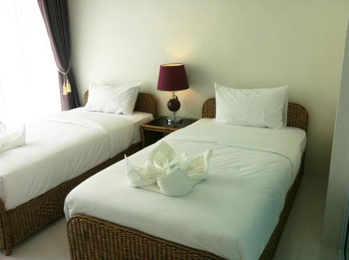 a hotel room with two beds with white pillows at Baancivilize Resort in Khanom