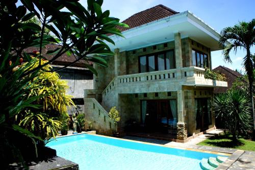 a house with a swimming pool in front of it at dewi ayu accomodation in Ubud