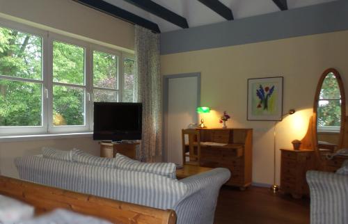a living room with a couch and a tv at Hotel Historischer Krug in Oeversee