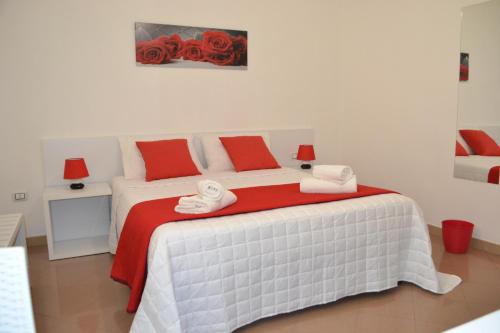 um quarto com uma cama com almofadas vermelhas e brancas em Bed Happy em Porto Cesareo
