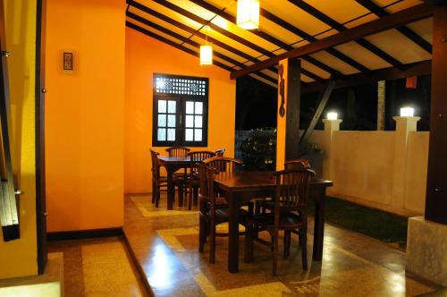 una sala da pranzo con sedie, tavolo e finestra di Sayo Villa a Negombo