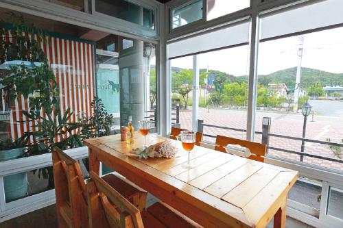 a wooden table with two glasses of wine on it at Yejeon Pension in Gyeongju