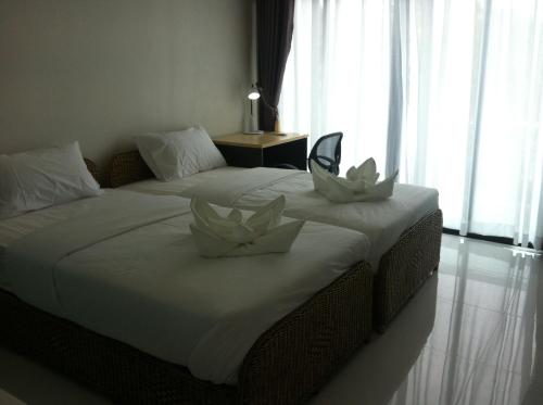 a bedroom with two beds with white flowers on them at Baancivilize Resort in Khanom