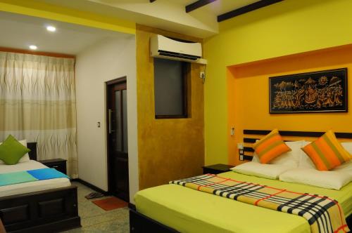 a hotel room with two beds and a window at Sayo Villa in Negombo