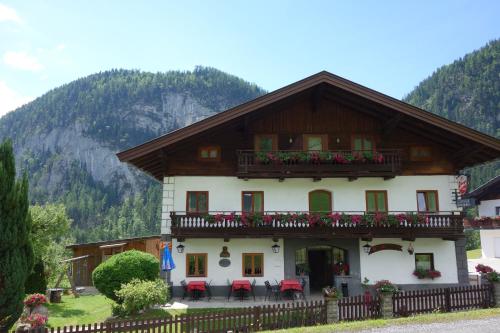 a house with a balcony with red chairs in front of it at Gasthof Dietrichshorn in Unken