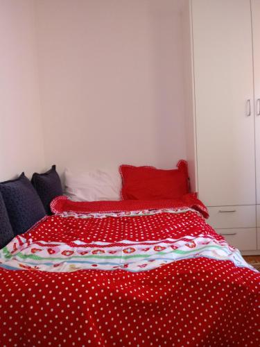 a bed with red and white polka dot sheets at Apartments Stan in Sarajevo