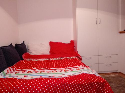 a bed with red polka dot sheets and red pillows at Apartments Stan in Sarajevo