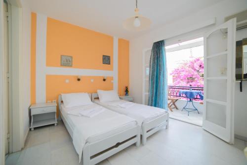 a bedroom with two beds and a balcony at Studios Stratos in Naxos Chora