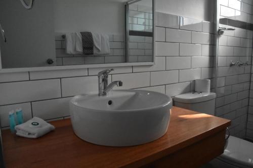 a white bathroom with a sink and a mirror at Ballina Homestead Motel in Ballina