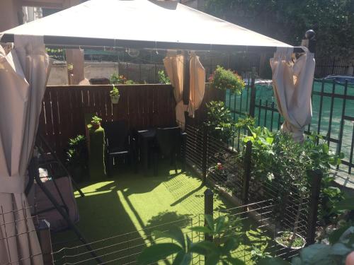 a garden with a white umbrella and some plants at City Garden Studio in Plovdiv