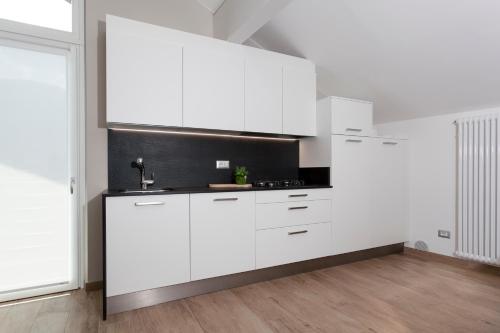 a white kitchen with white cabinets in a room at Residenza Al Cadin in Andalo