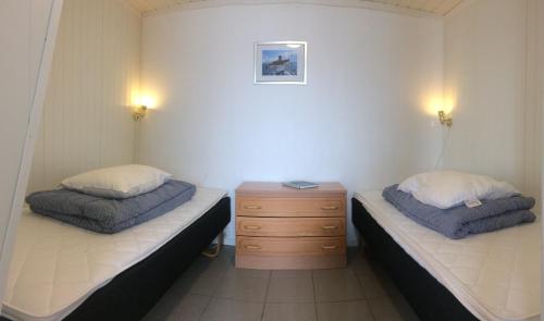 Habitación con 2 camas y tocador de madera. en Arctic Seasport en Løding