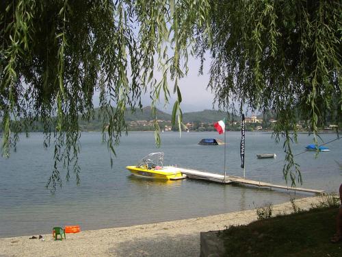 a yellow boat on the water next to a dock at Caprice in Avigliana