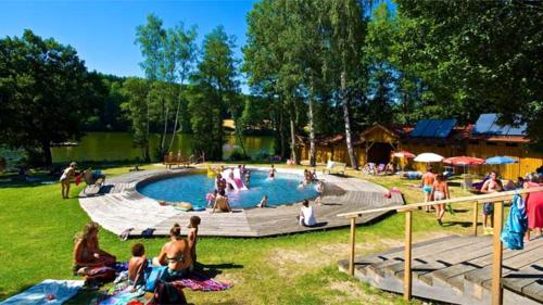 a group of people sitting around a swimming pool at Erholungswald Herrensee in Litschau
