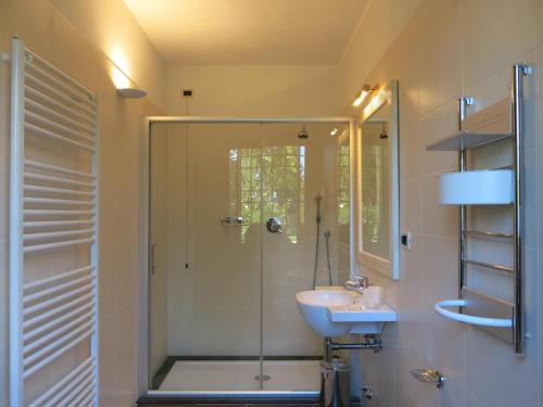 a bathroom with a glass shower and a sink at Villa Schiavi in Sermide