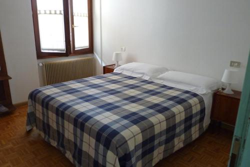 a bedroom with a blue and white checkered bed at Appartamento Masi in Lasino