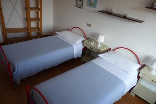 two beds in a hotel room with two bedsskirts at Appartamento Masi in Lasino