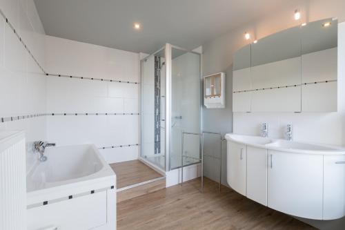 赫拉爾茲貝亨的住宿－Sekowa-lodge，白色的浴室设有浴缸和水槽。