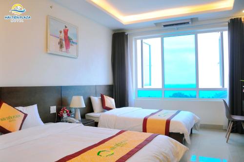 a hotel room with two beds and a window at Hai Tien Plaza Hotel in Mỹ Ðuc