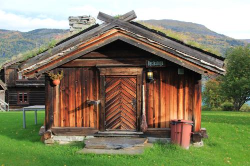 a small cabin with a wooden door in a field at Sygard Storrvik in Storrvik
