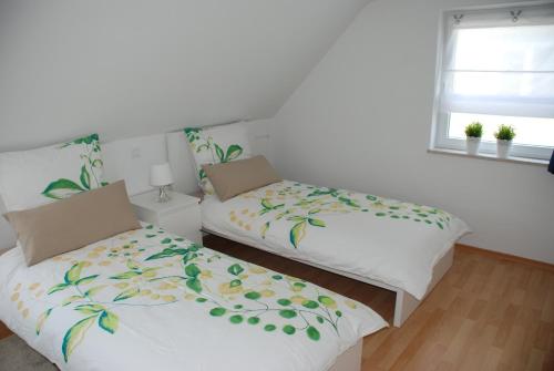 - 2 lits installés l'un à côté de l'autre dans une chambre dans l'établissement Ferienwohnungen Lisa, à Wangen im Allgäu