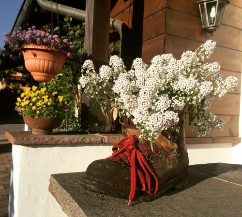 a vase filled with white flowers on a ledge at Gatterhof in Riezlern