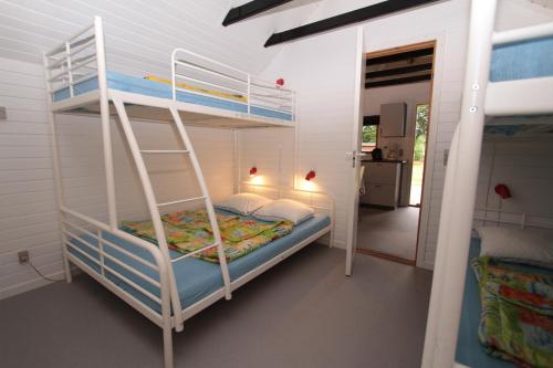 Husodde Strand Camping & Cottages في هورسنز: سرير بطابقين في غرفة مع سلم