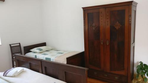 a bedroom with a wooden cabinet next to a bed at Guesthouse Lidija in Sutivan