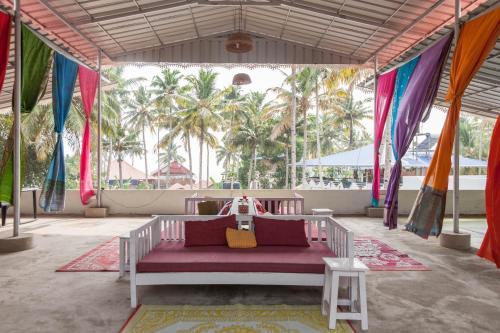 a bed in a tent with palm trees in the background at Mad about Coco Yoga & Beach Retreat in Varkala