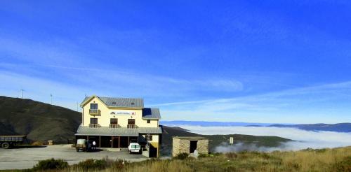 a house on top of a hill with fog in the background at Pedras Lavradas in Teixeira de Baixo