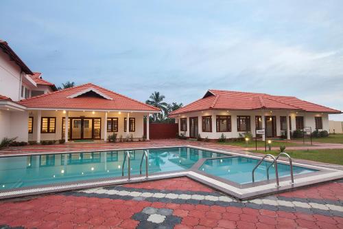 a swimming pool in front of a house at Le Coffee Resort in Sultan Bathery