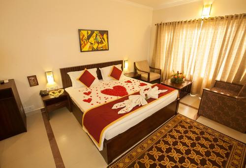 a bedroom with a large bed and a chair at Le Coffee Resort in Sultan Bathery