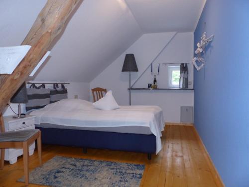 ein Schlafzimmer mit einem Bett und einer blauen Wand in der Unterkunft Ferienhaus Arendsee in Arendsee