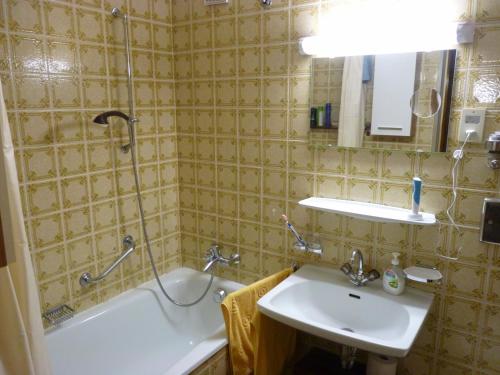 a bathroom with a sink and a bath tub and a sink at Apartment Anna in Bad Gastein