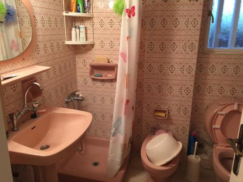 a pink bathroom with a sink and a toilet at Vlastos Apartment in Kalamos