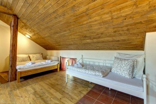 a room with two beds and a wooden ceiling at Slezský Grunt in Háj ve Slezsku